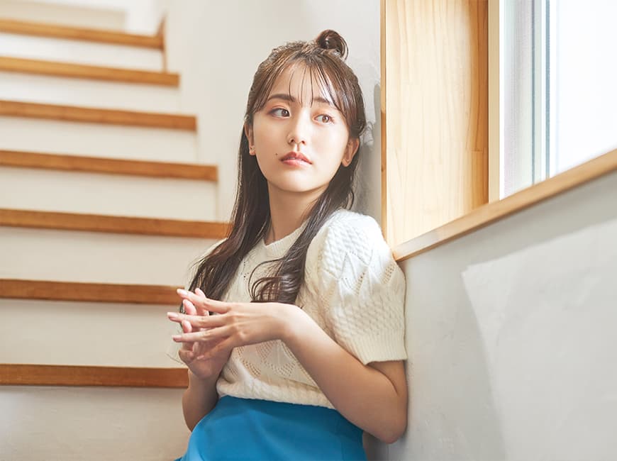 女性が腕を上げて、遠くを眺めている様子